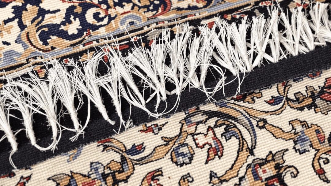 Franges abîmées d'un tapis oriental en cours de réparation artisanale